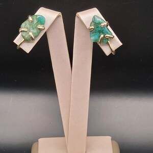 Vintage clip-on earings featuring a raw or rough-cut polished green gemstone